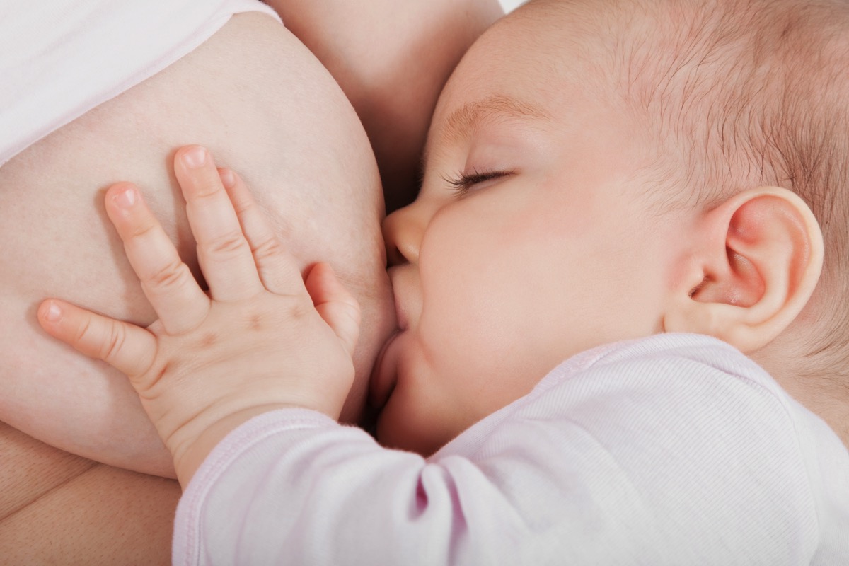 Madre sonriente cargando a su bebé, simbolizando compatibilidad entre reducción de mamas y lactancia. Dr. Esteban Torres.